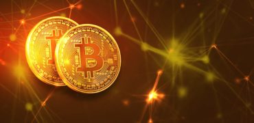two bitcoins on golden background